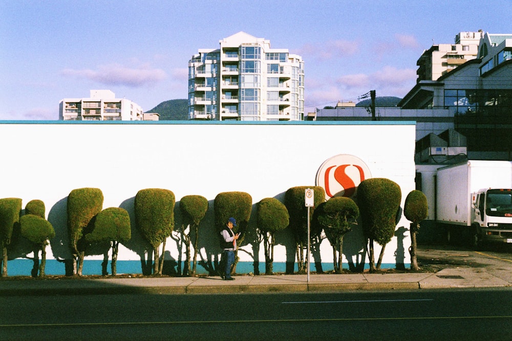 a man sitting on a bench in front of a wall