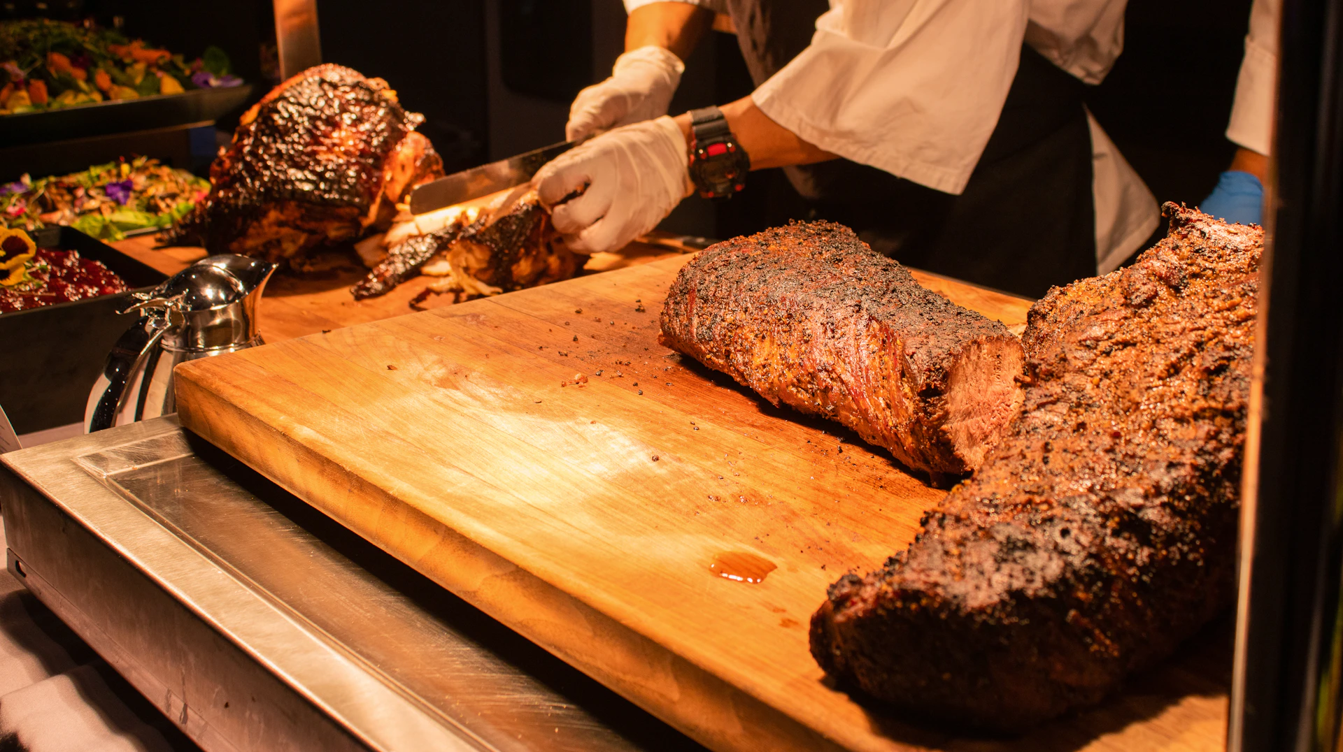 An expert cortador carefully slicing a leg of jamón ibérico with precision during a festive birthday party.