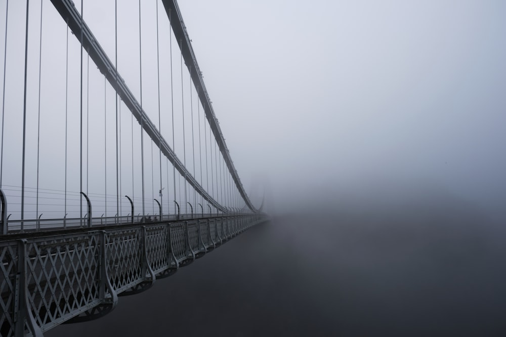 a foggy bridge with a few cars on it