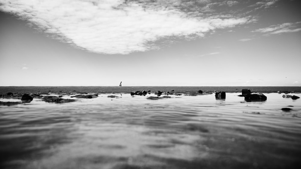 a black and white photo of rocks in the water