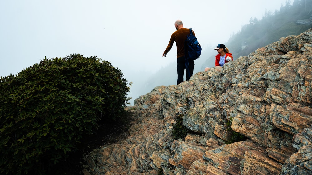 a man and a woman hiking up a mountain