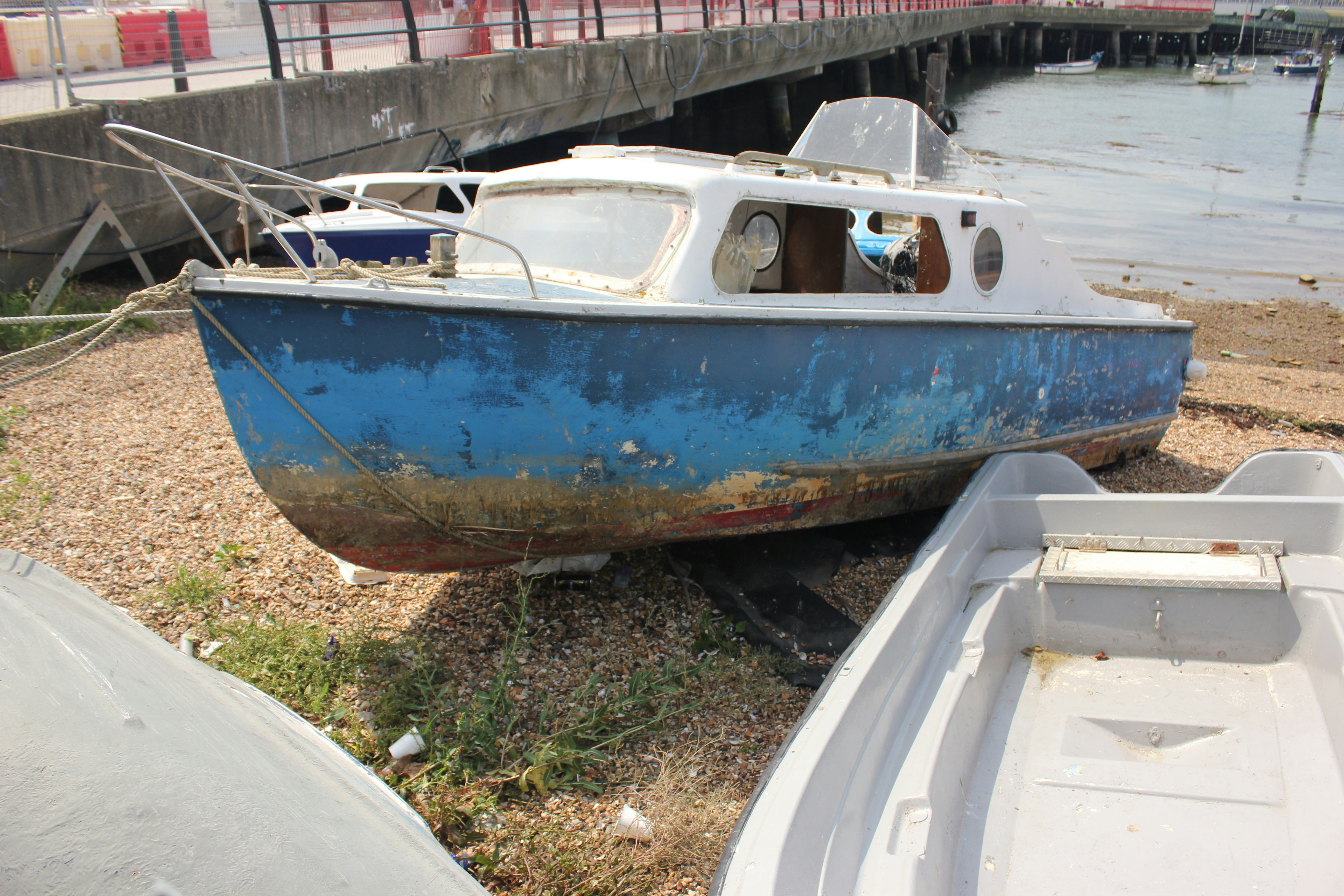 a blue and white boat sitting on top of a beach
