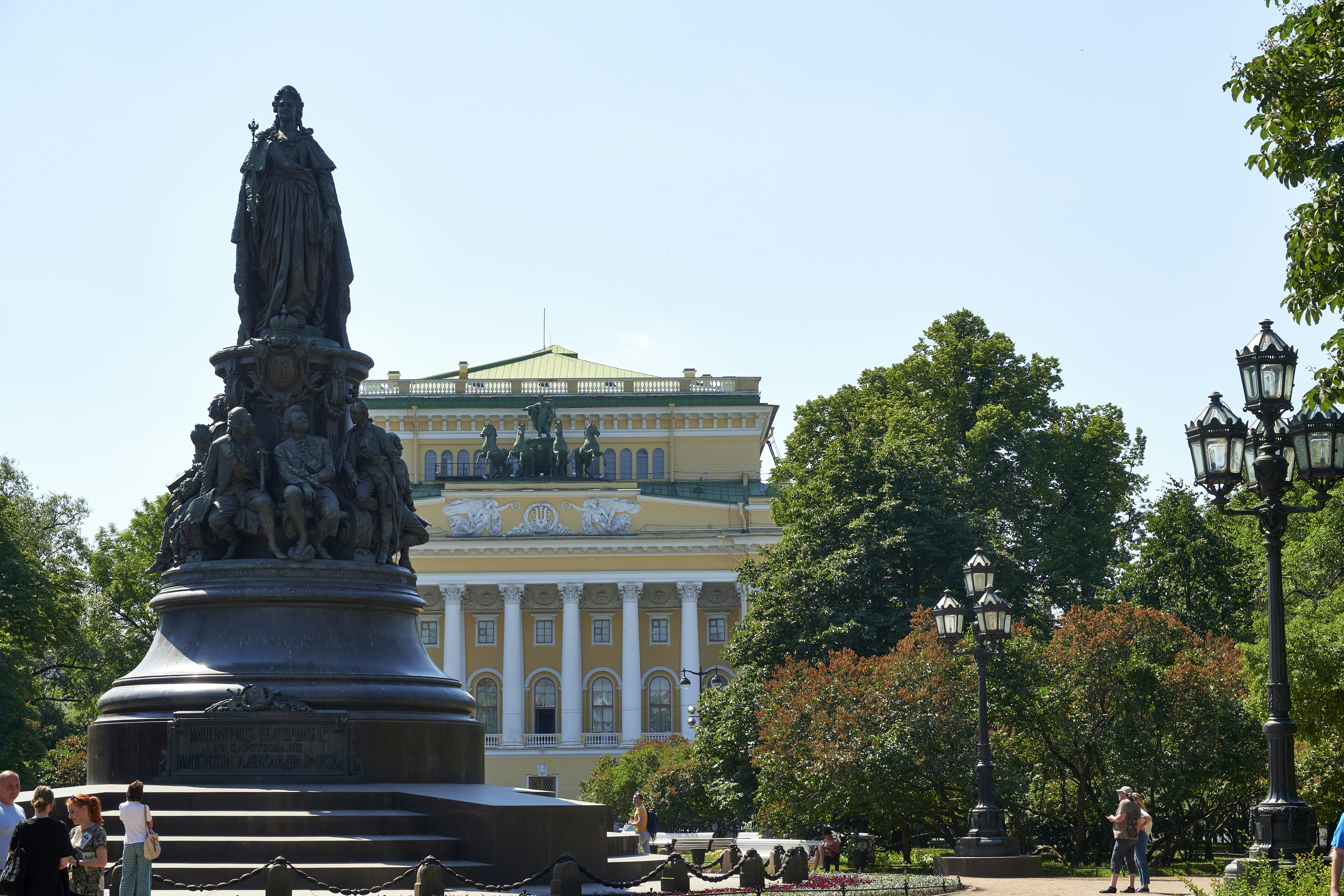 a statue in front of a yellow building