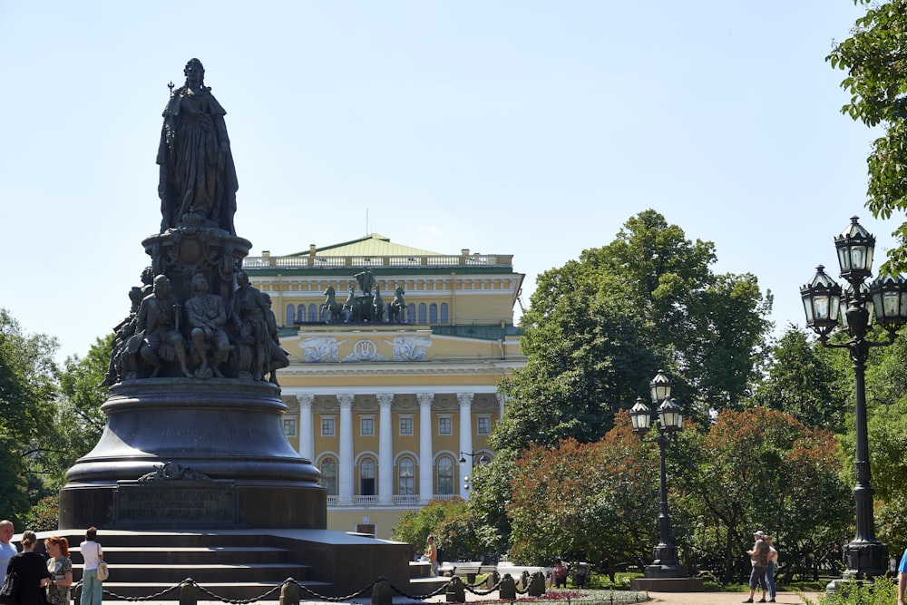 a statue in front of a yellow building