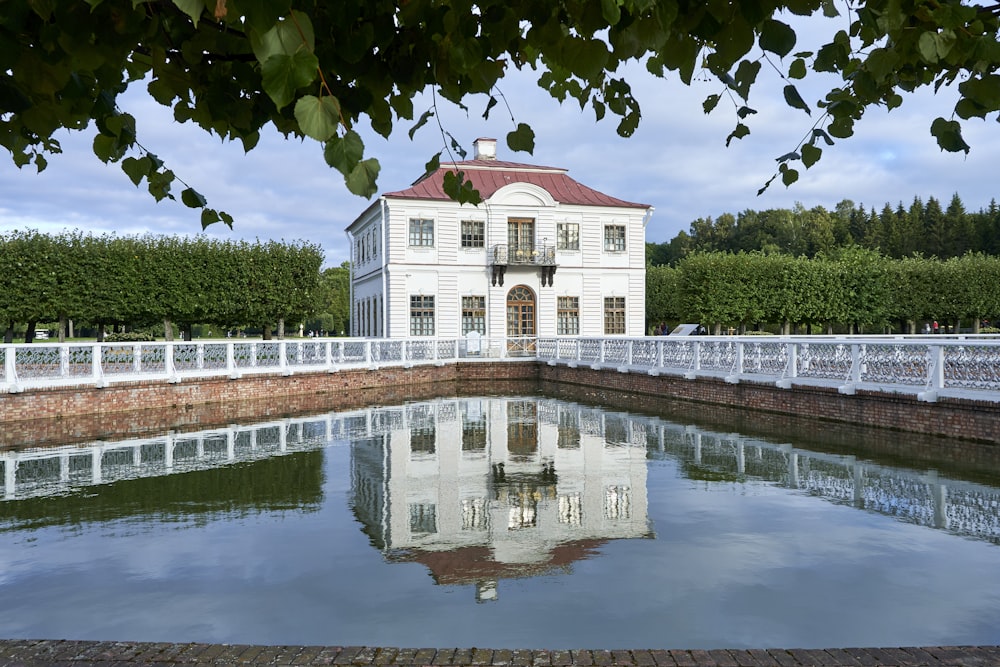 a large white house sitting next to a body of water