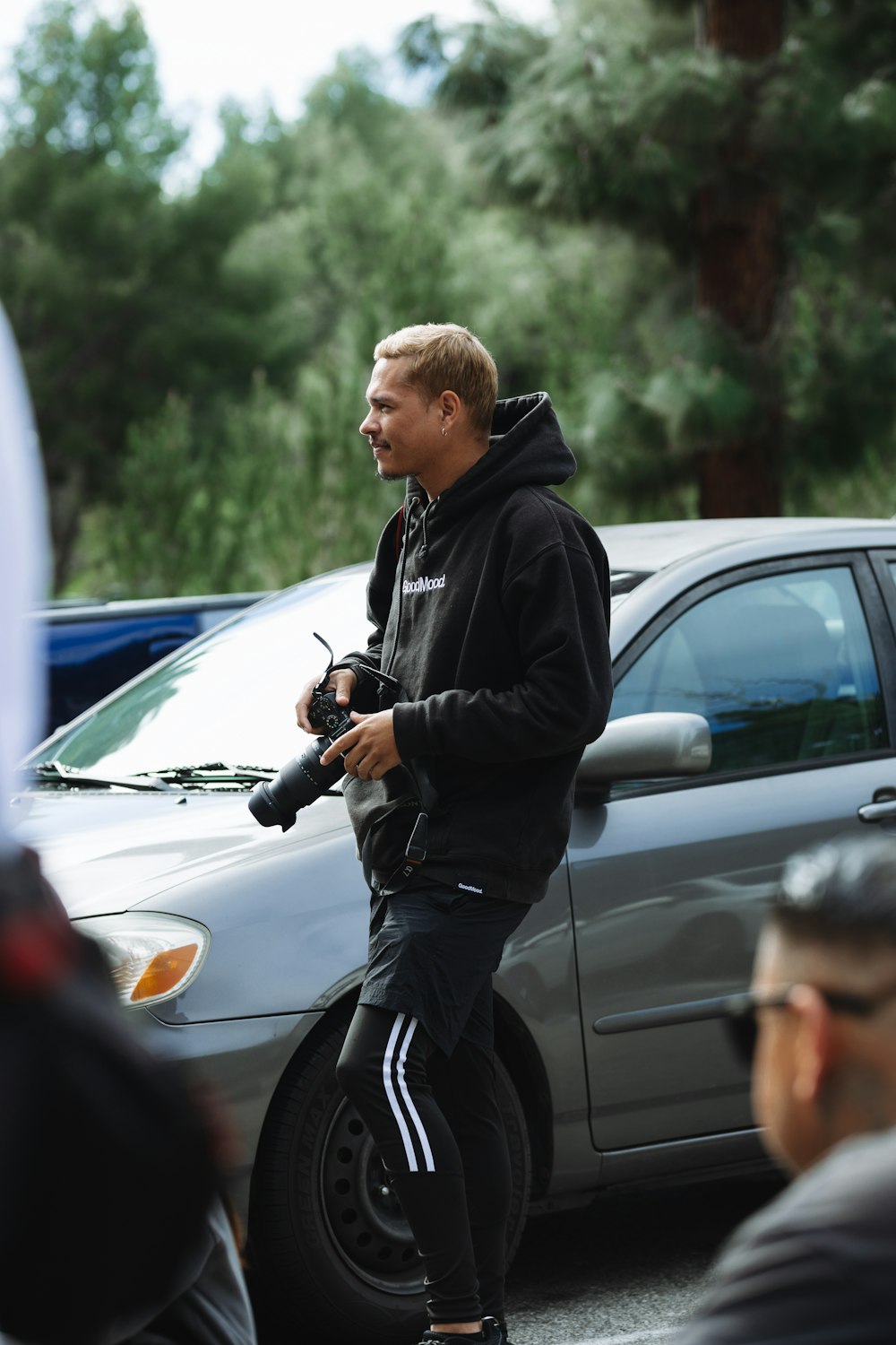 a man in a black hoodie is riding a scooter