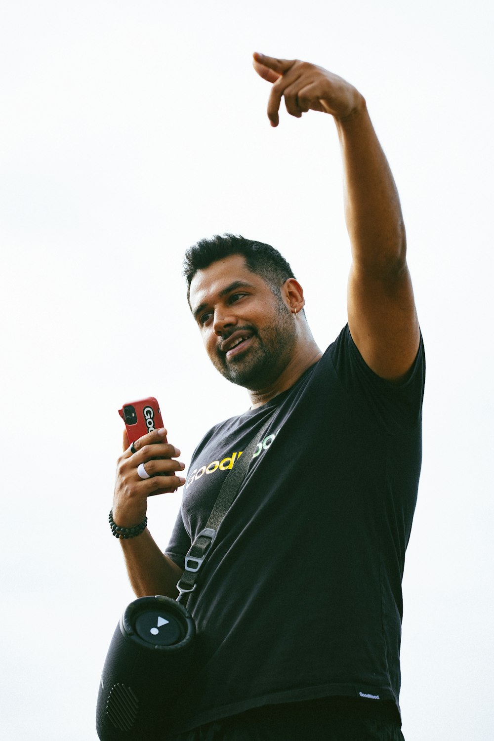 a man holding a cell phone up in the air