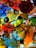 A vibrant and colorful glass sculpture consisting of various intricate patterns and shapes. The artwork features a harmonious blend of colors, including vivid blues, reds, oranges, yellows, and greens, creating a dynamic and mesmerizing visual experience. The glass pieces are layered and interwoven, each exhibiting unique textures and designs.