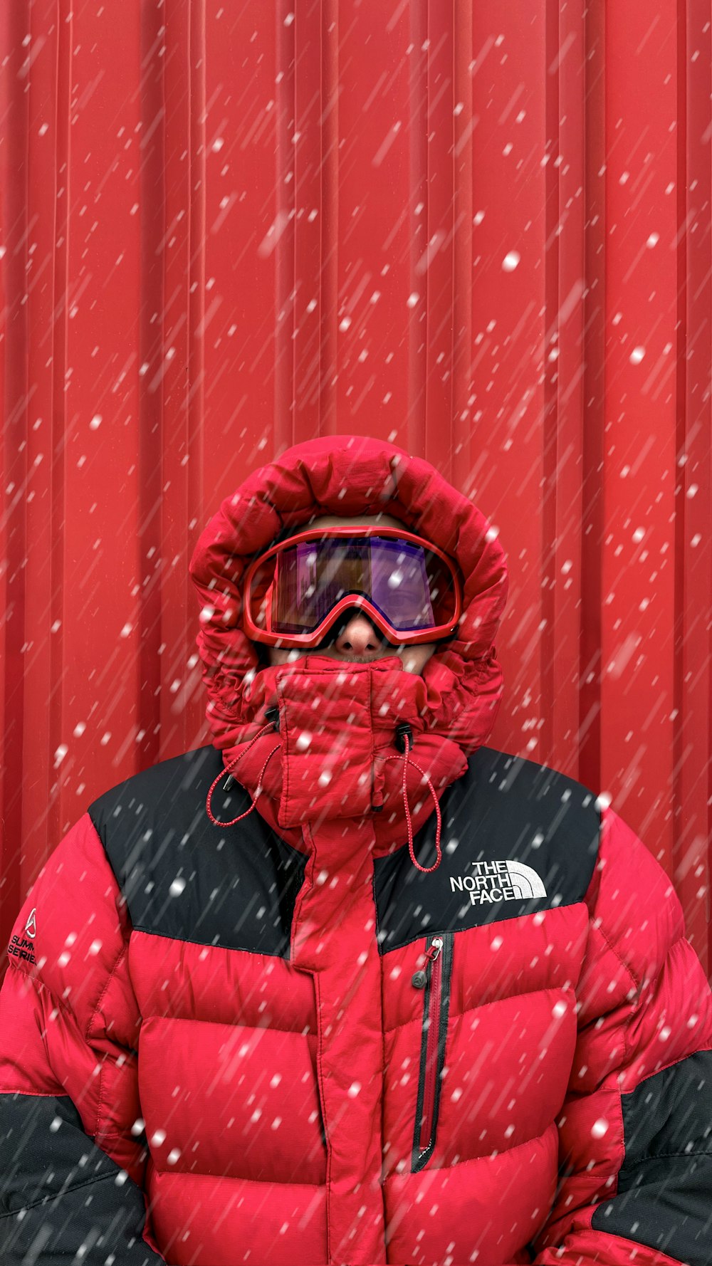 a man wearing a red jacket and goggles