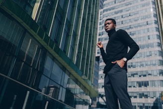 A professional security guard standing confidently in front of a modern office building during sunset.