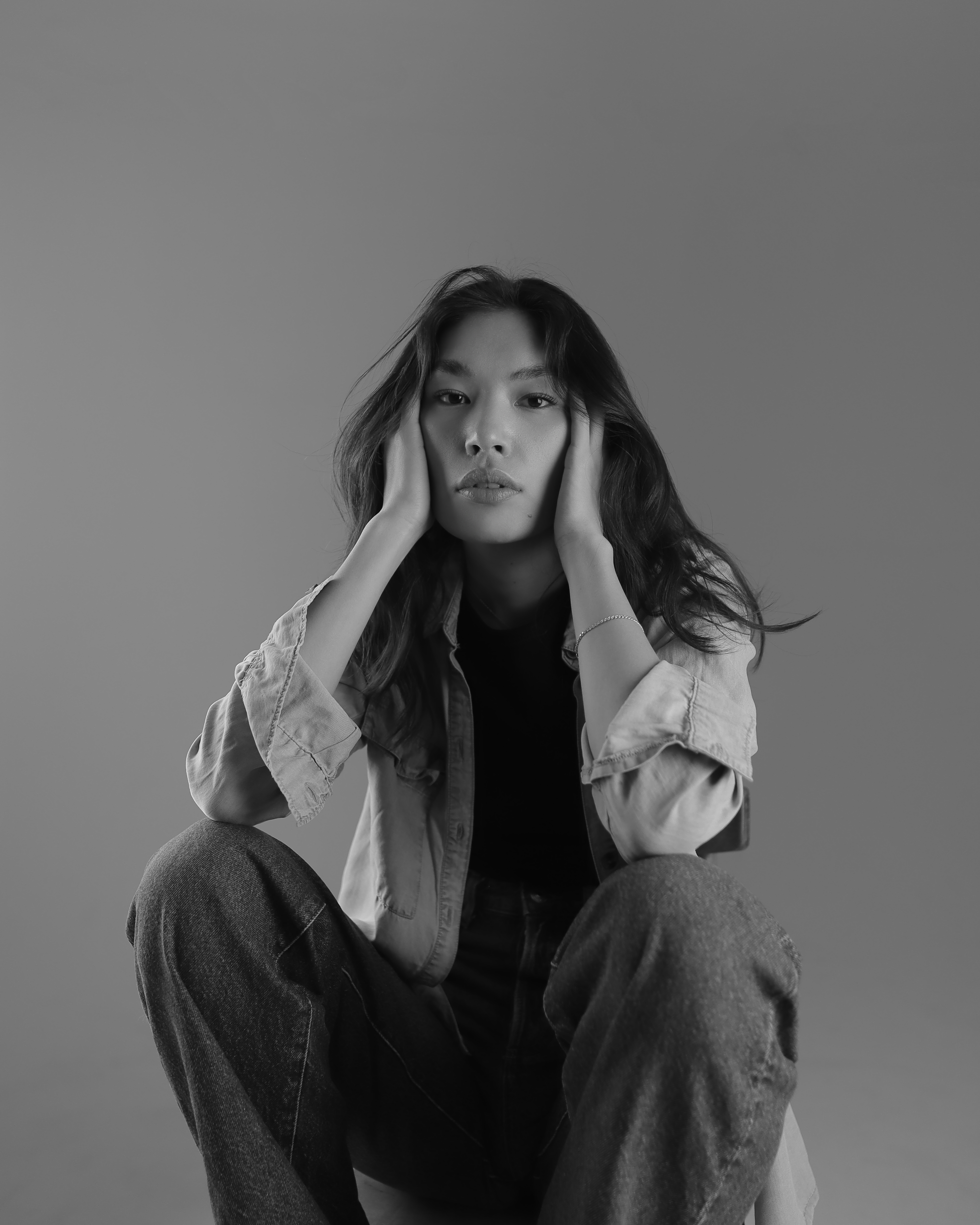 a black and white photo of a woman sitting on the ground
