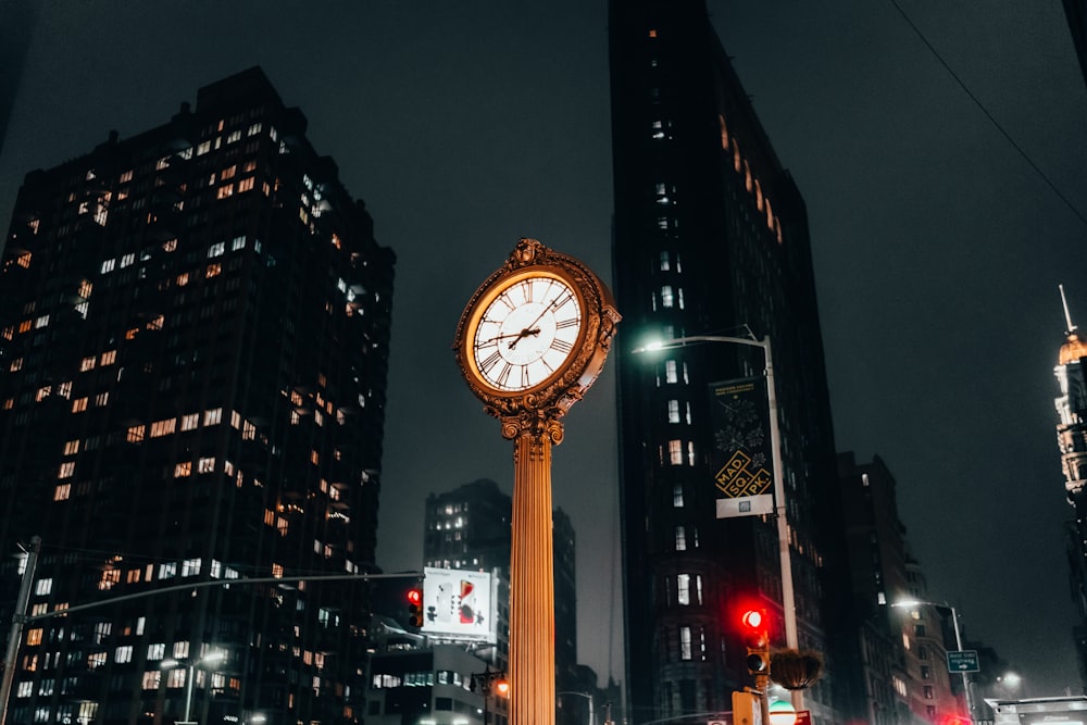 a clock on a pole in the middle of a city