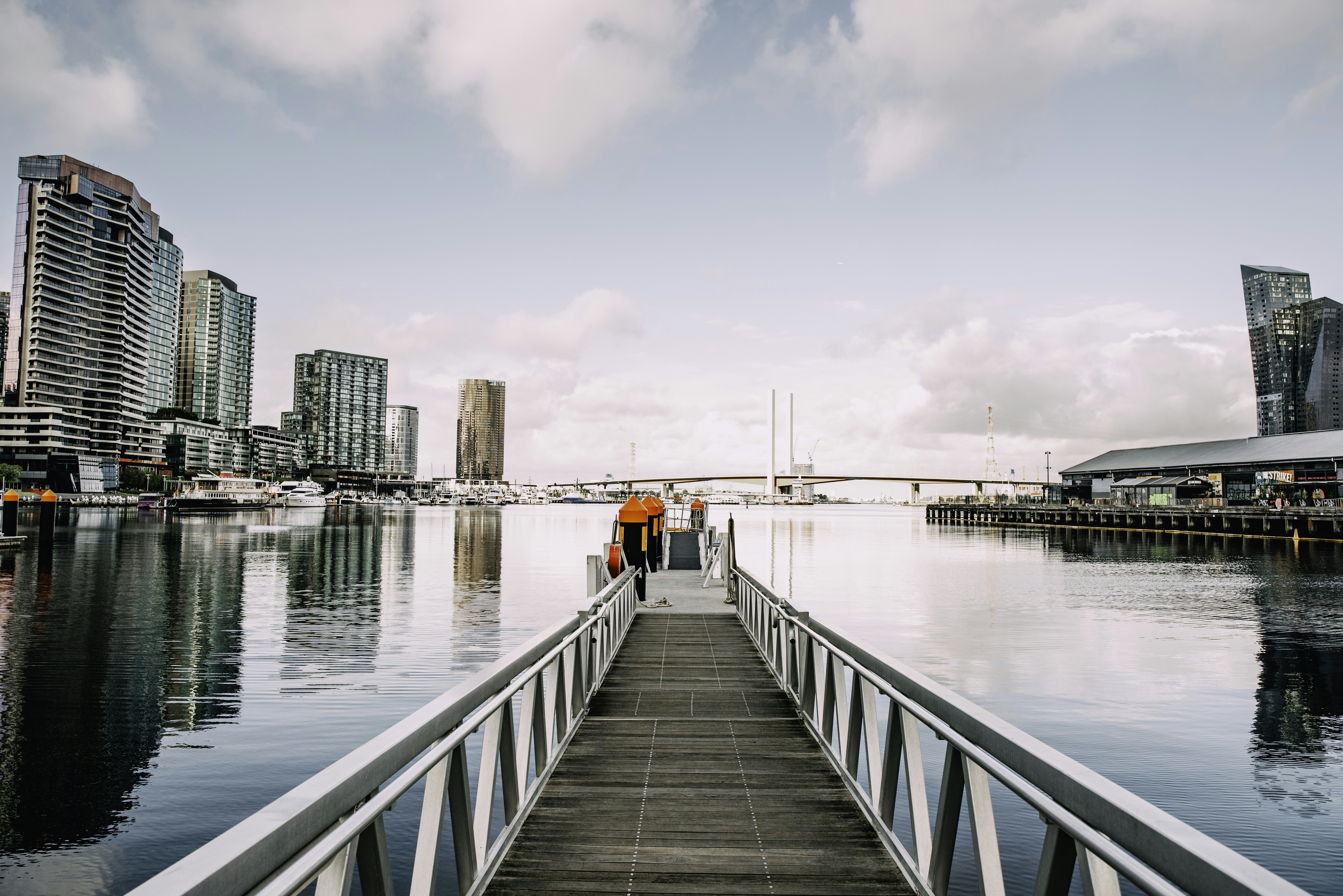 two people standing on a dock near a body of water