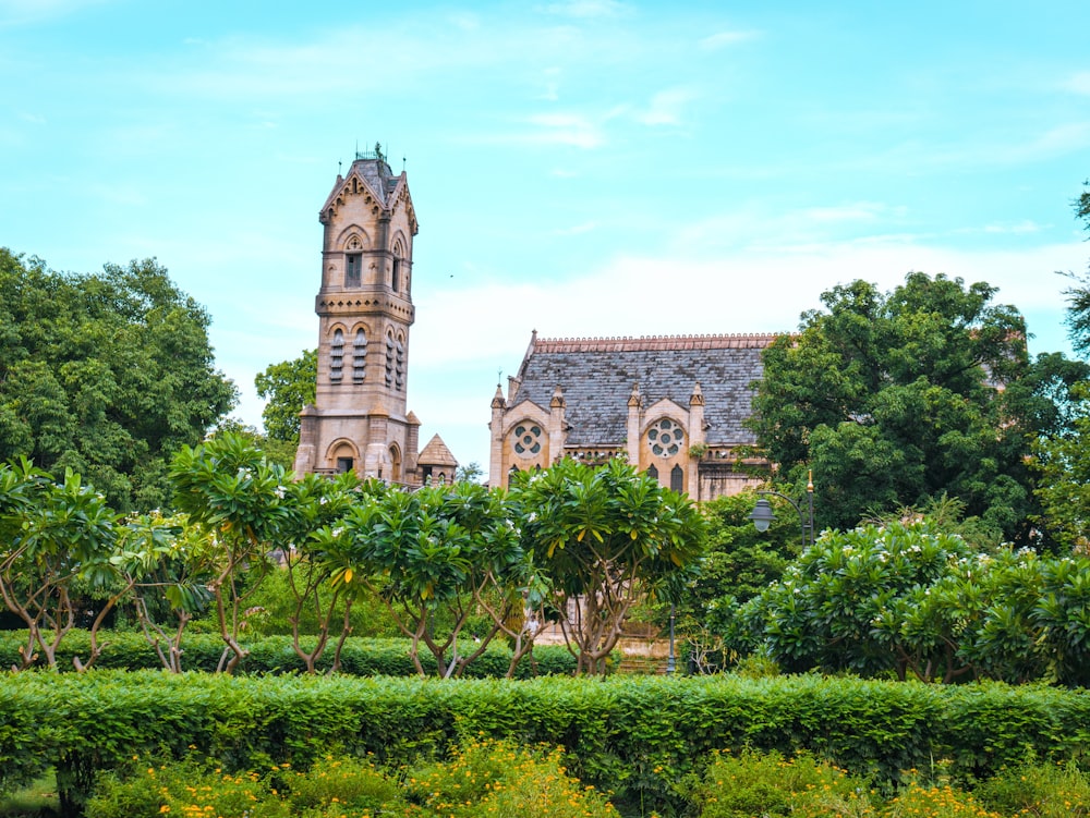 a large building with a clock tower in the middle of trees