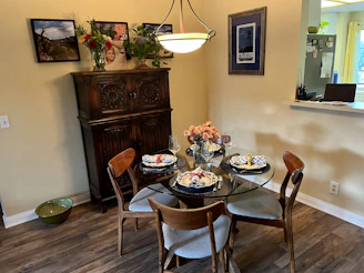 A cozy dining table set with a beautifully patterned Velora tablecloth, surrounded by family enjoying a meal.