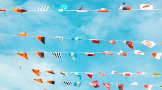 A vibrant collage of international flags fluttering against a clear blue sky