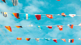 Flags of many nations waving together under a hopeful sky.