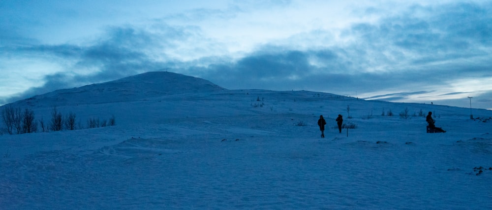 a group of people standing on top of a snow covered slope