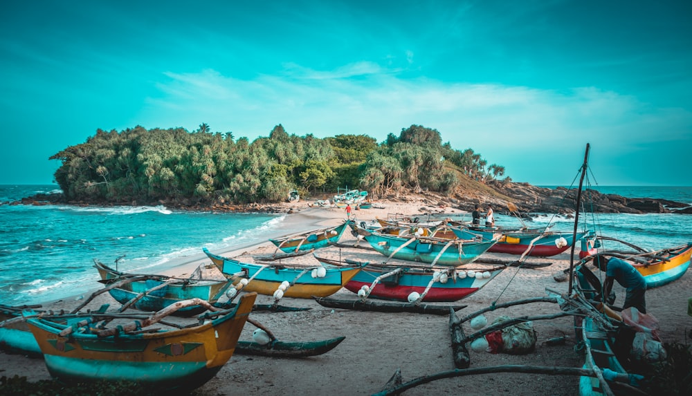 a group of boats sitting on top of a sandy beach