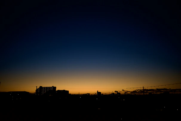 A vibrant illustration showing NYC skyline merging into Tel Aviv's coastline at sunset.