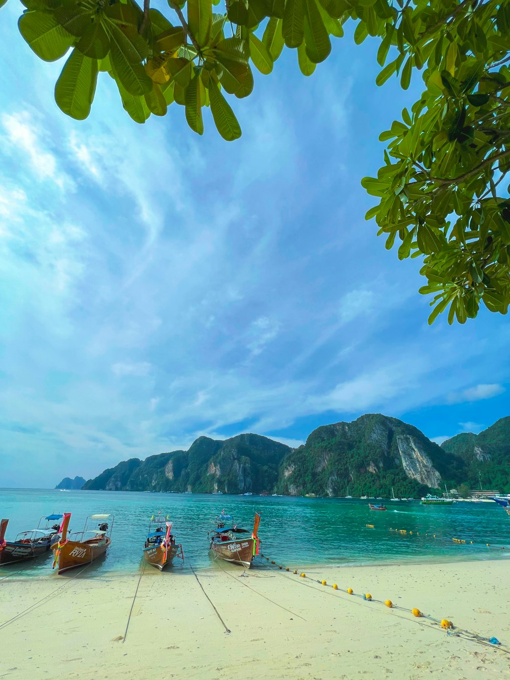 a couple of boats sitting on top of a sandy beach