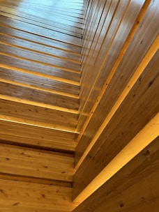 Wooden slats are arranged vertically and horizontally, creating a pattern with a warm, natural texture. The wood appears smooth and polished, with visible grain patterns and knots.