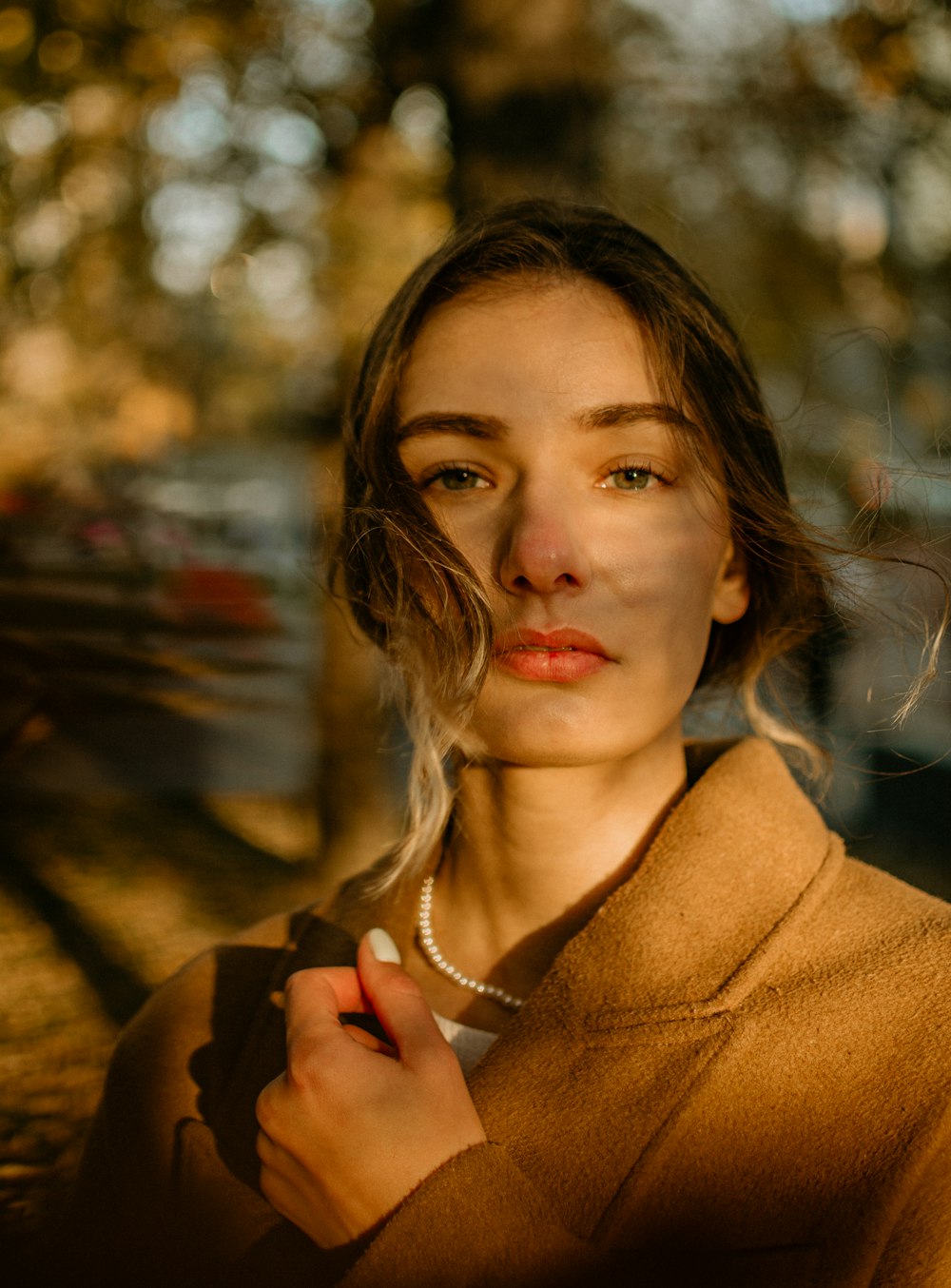 a woman in a brown sweater is holding a cigarette
