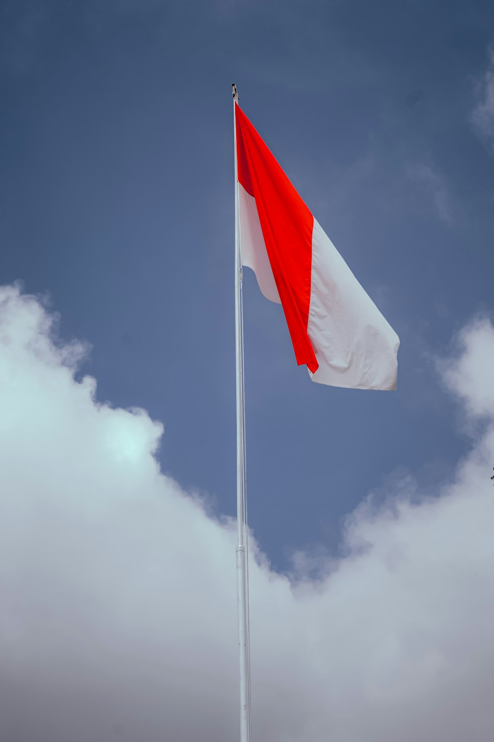 a red and white flag flying in the sky