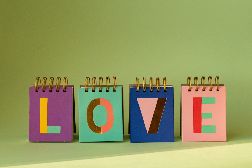 a row of colorful notepads with the word love written on them