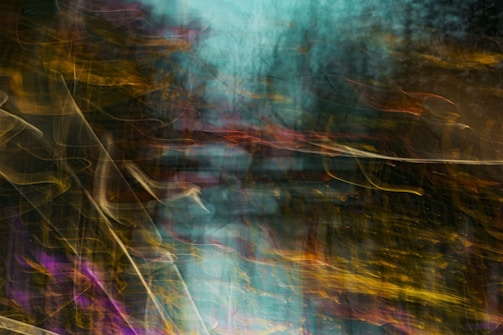 A dynamic abstract composition featuring swirling patterns of light and color. The image blends shades of teal, gold, and purple with blurred, flowing lines, creating a sense of motion and chaos.