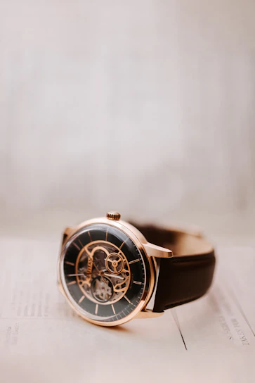 Close-up of a sleek md tertius watch with a minimalist dial resting on a wooden surface.