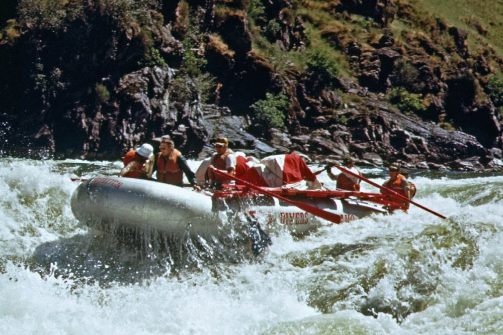 a group of men riding on the back of a raft down a river