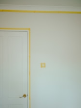 a room with a white door and a yellow strip on the wall