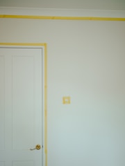 a room with a white door and a yellow strip on the wall
