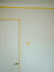 a room with a white door and a yellow strip on the wall