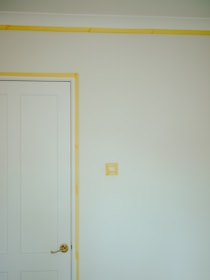 a room with a white door and a yellow strip on the wall