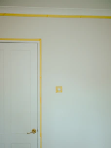 a room with a white door and a yellow strip on the wall