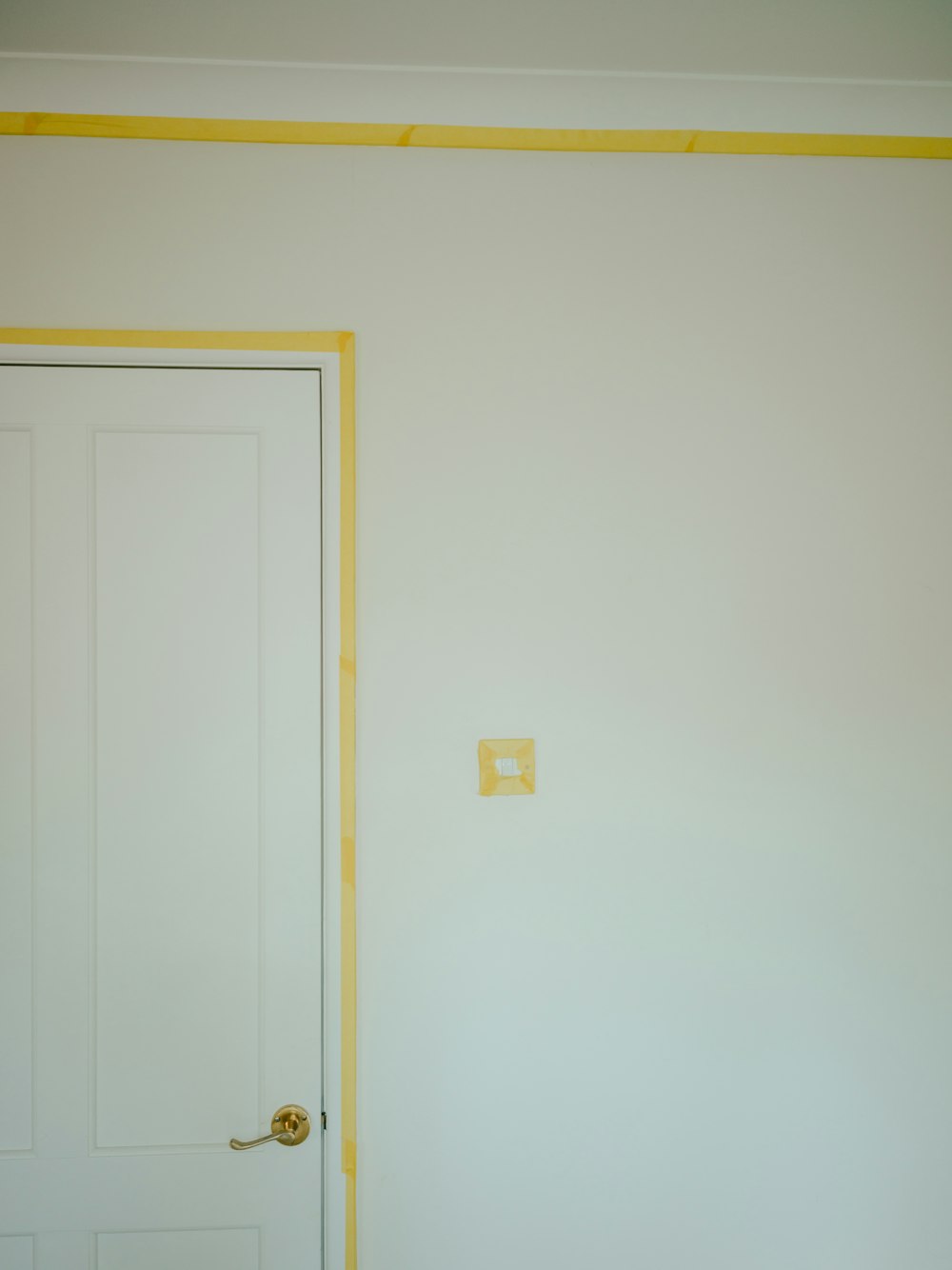 a room with a white door and a yellow strip on the wall