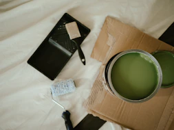a green paint can sitting on top of a cardboard box