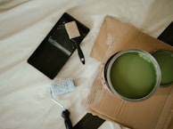 a green paint can sitting on top of a cardboard box