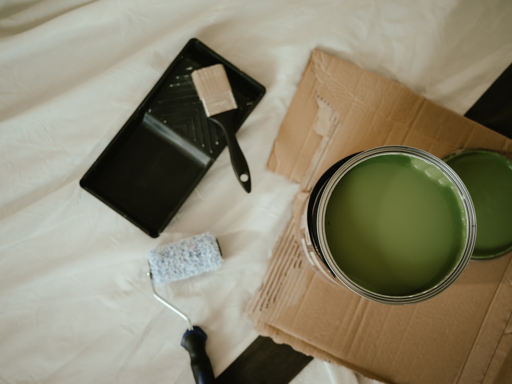 a green paint can sitting on top of a cardboard box