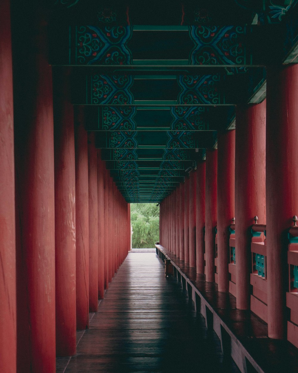 a long walkway lined with red pillars and lanterns