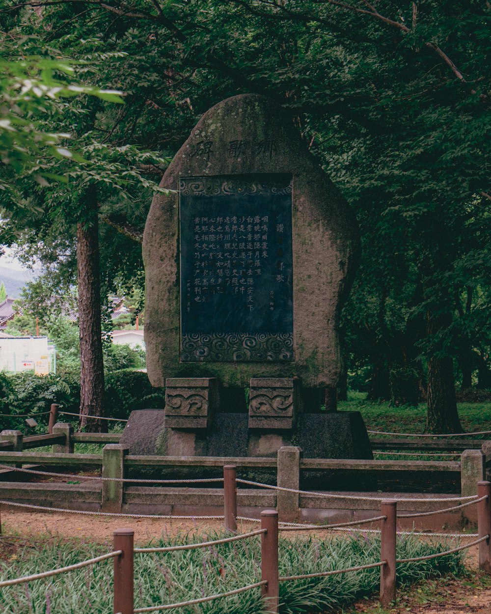 a stone monument with writing on it in a park