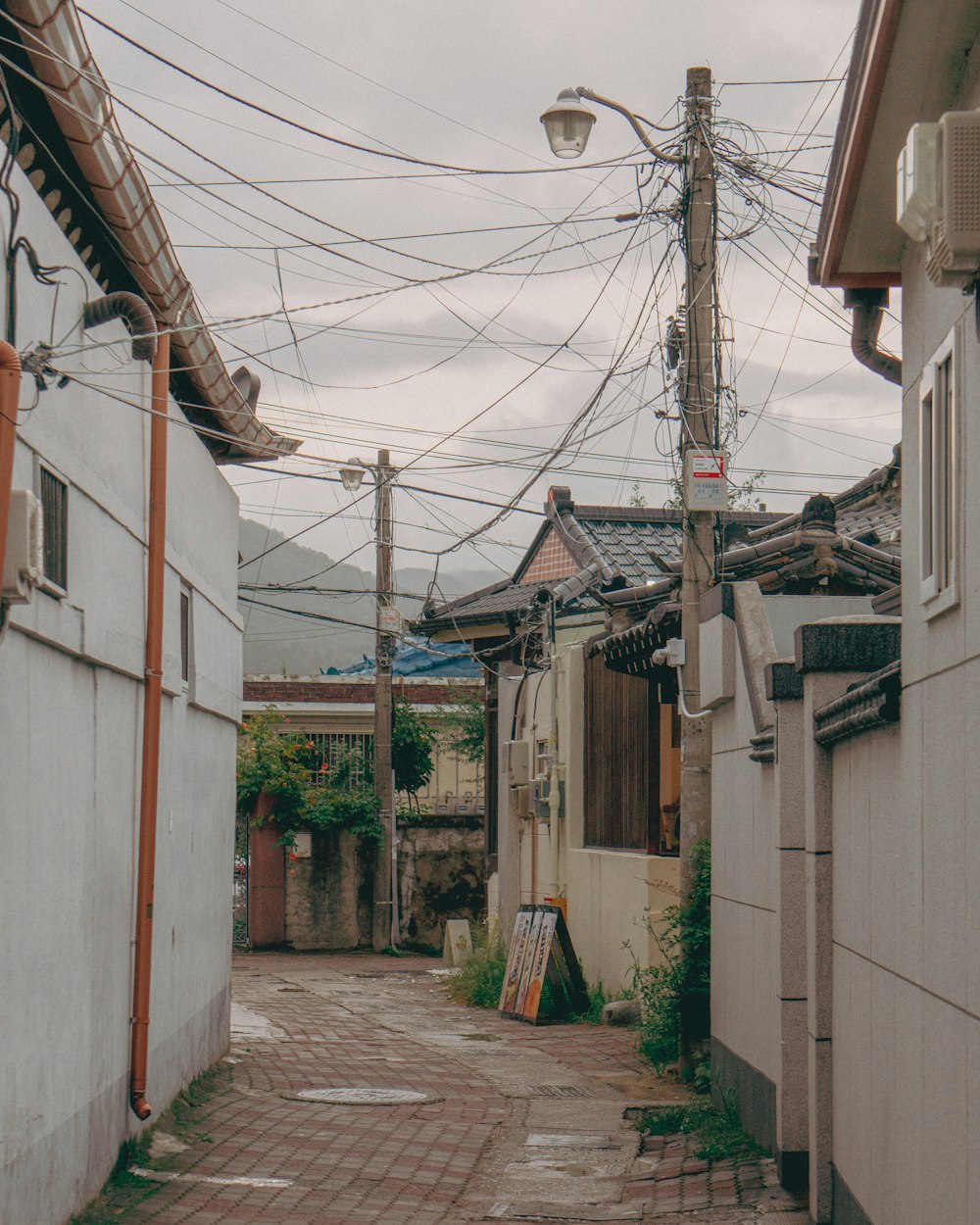 an alley way with a bunch of power lines above it