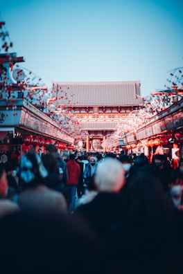 A bustling Asian street market filled with lanterns, fresh produce, and smiling vendors.