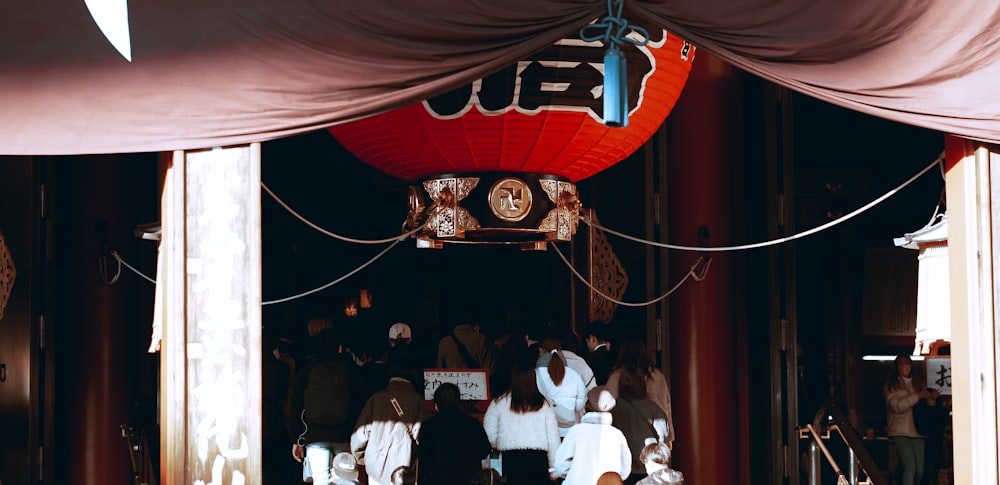 a group of people standing under a red lantern