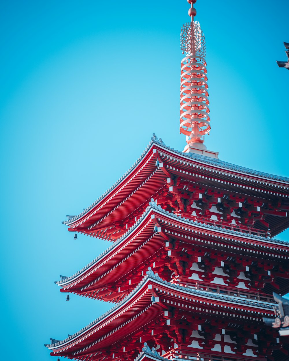 Una alta pagoda roja con un cielo azul en el fondo