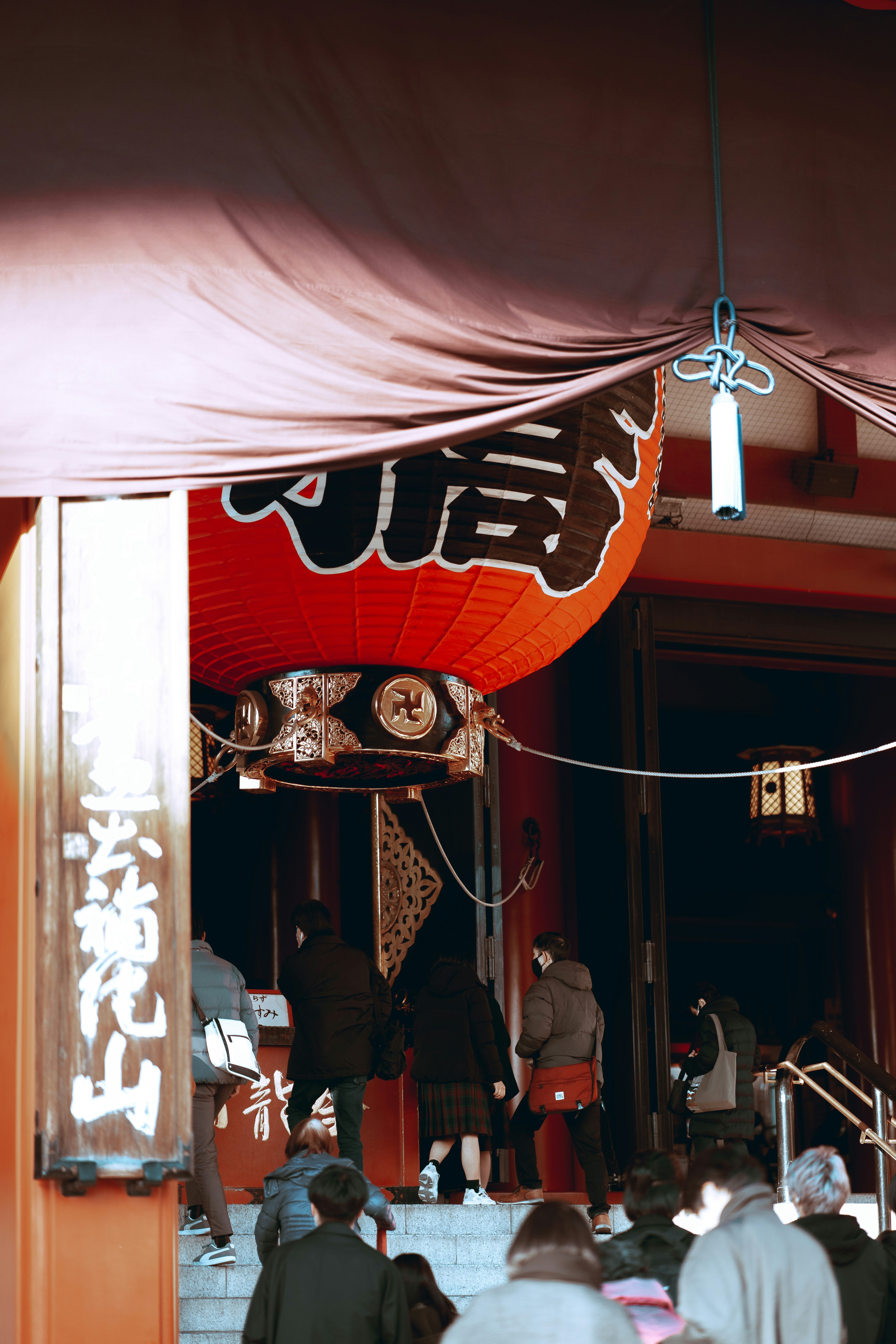 a group of people standing under a red umbrella