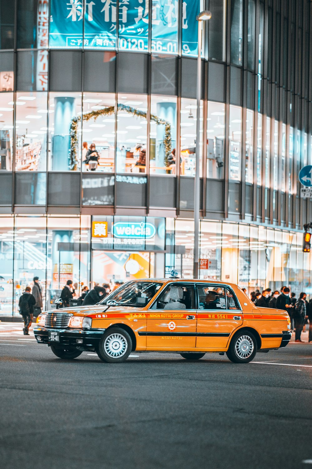 an orange taxi cab driving down a street at night