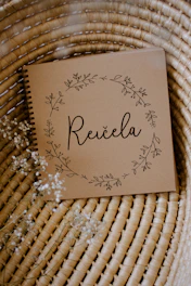 A white notebook cover adorned with a delicate black mandala design symbolizing spiritual balance.
